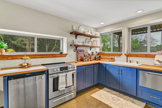 kitchen with stainless steel appliances, blue cabinets, and sink