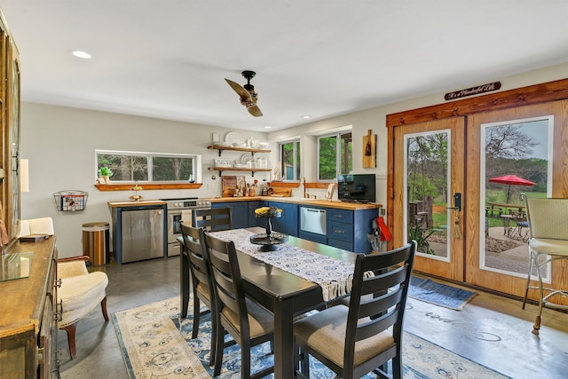 dining area with ceiling fan, concrete flooring, and french doors