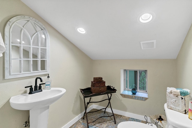 bathroom featuring lofted ceiling and toilet