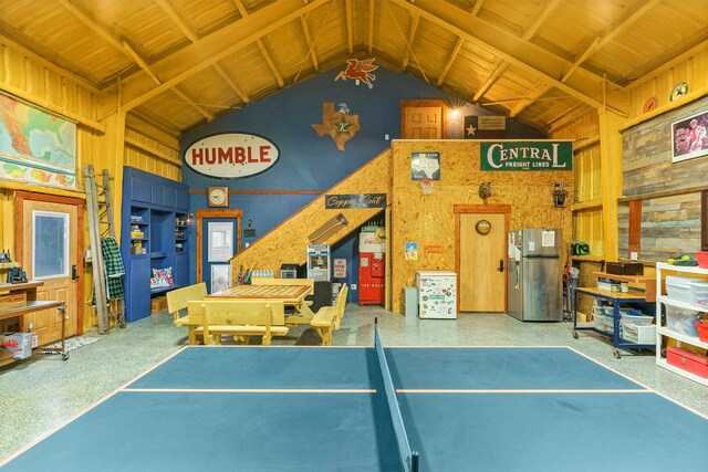 game room featuring wood walls and vaulted ceiling