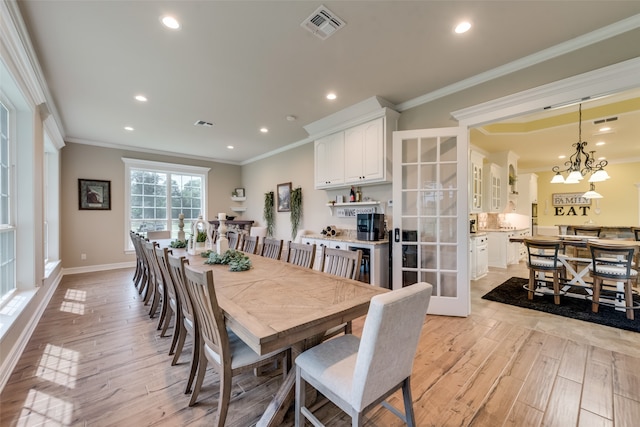 dining room featuring ornamental molding, light hardwood / wood-style flooring, and a chandelier