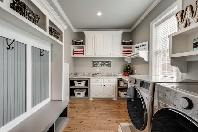 laundry room with plenty of natural light, ornamental molding, light hardwood / wood-style floors, and washing machine and clothes dryer