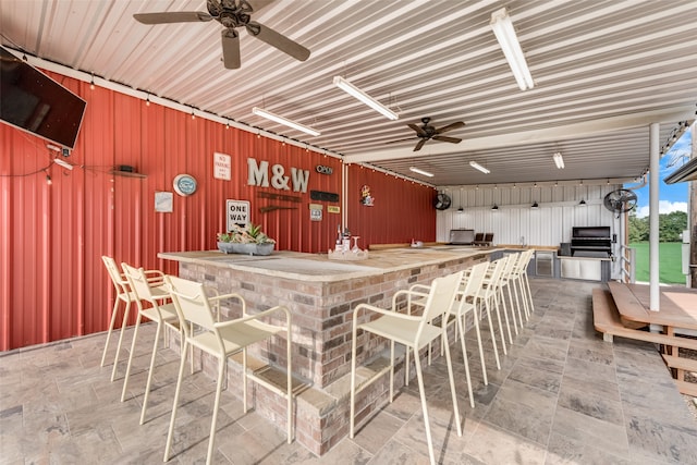 interior space with exterior bar and ceiling fan