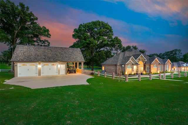 back house at dusk featuring a lawn