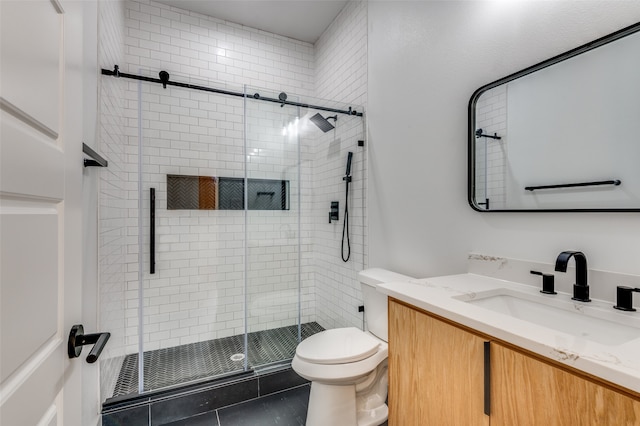 bathroom with a shower with door, tile flooring, vanity, and toilet