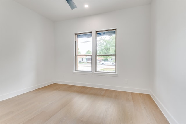 empty room with a wealth of natural light and light hardwood / wood-style floors