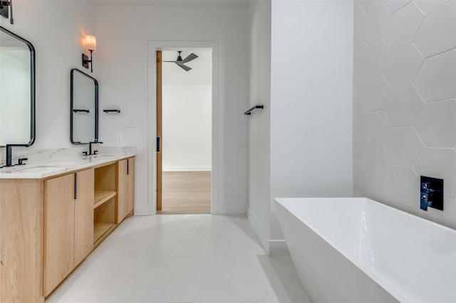 bathroom featuring a bathtub, dual vanity, and tile flooring