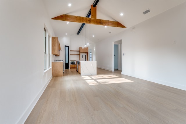 unfurnished living room with high vaulted ceiling, beamed ceiling, and light wood-type flooring