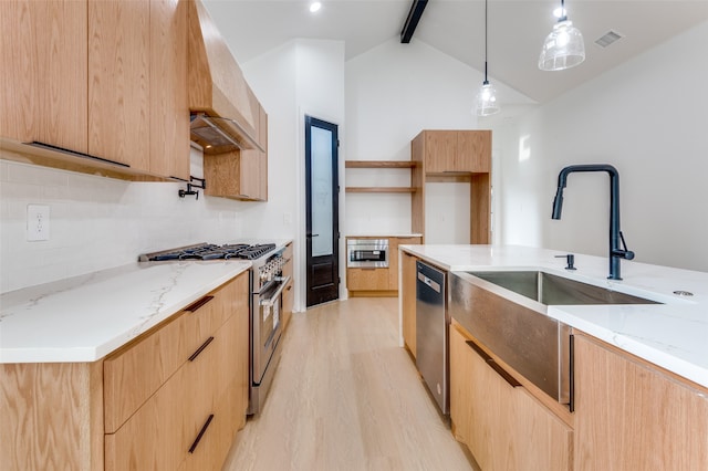 kitchen featuring light stone counters, light hardwood / wood-style flooring, stainless steel appliances, and hanging light fixtures