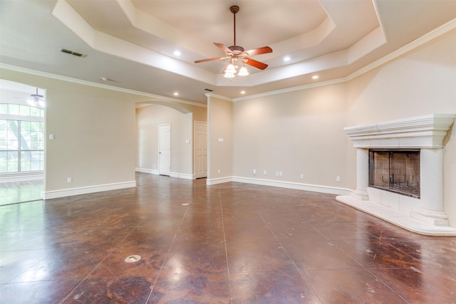 unfurnished living room with a tray ceiling, crown molding, and a tiled fireplace