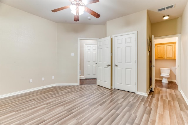 unfurnished bedroom featuring ceiling fan, ensuite bath, and light hardwood / wood-style flooring