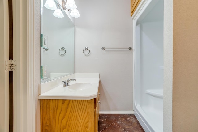 bathroom with vanity, an inviting chandelier, and tile patterned floors