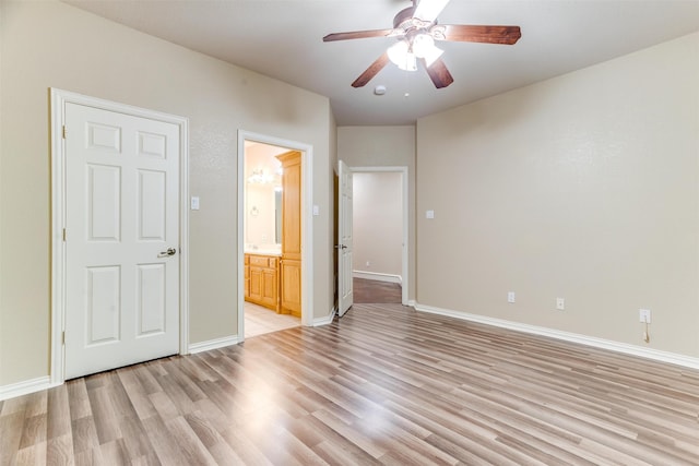 unfurnished bedroom featuring ceiling fan, ensuite bathroom, and light wood-type flooring