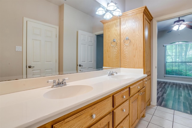 bathroom with tile patterned floors, vanity, and ceiling fan with notable chandelier