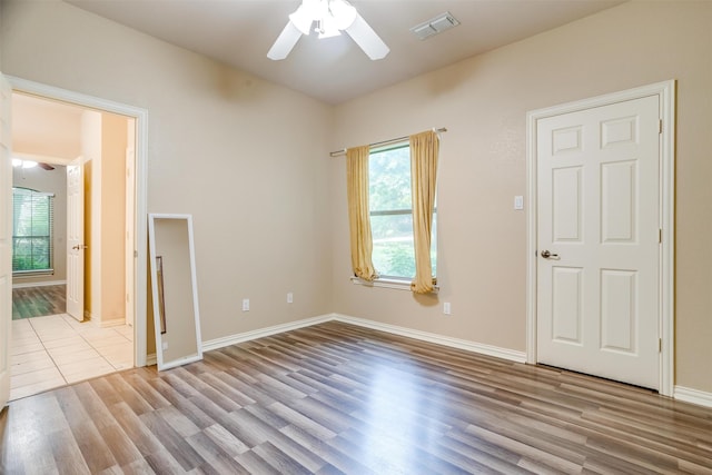 spare room with ceiling fan and light wood-type flooring