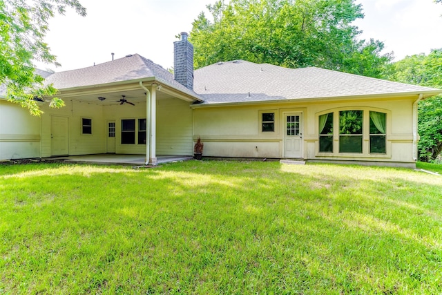 rear view of property featuring a patio and a lawn