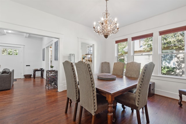 dining space featuring dark hardwood / wood-style flooring and a chandelier