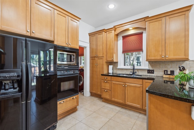 kitchen with backsplash, sink, black appliances, light tile patterned floors, and dark stone countertops