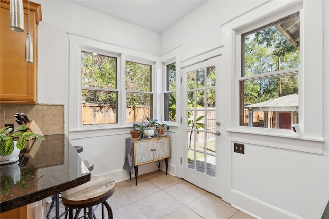 doorway to outside with a wealth of natural light and light tile patterned floors