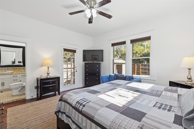 bedroom with connected bathroom, dark hardwood / wood-style flooring, multiple windows, and ceiling fan