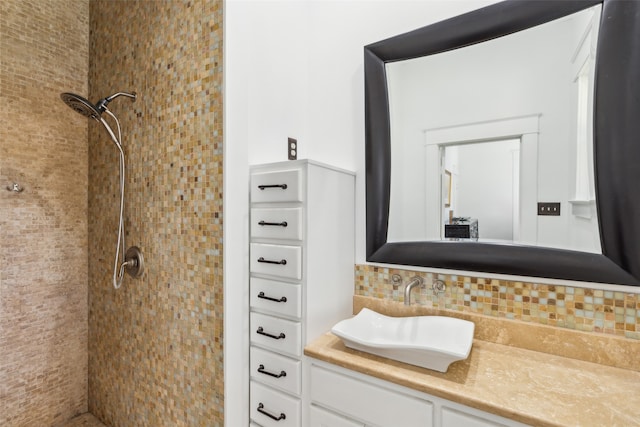 bathroom with tiled shower, decorative backsplash, and vanity