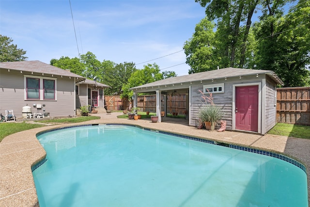 view of pool featuring an outbuilding and a patio area