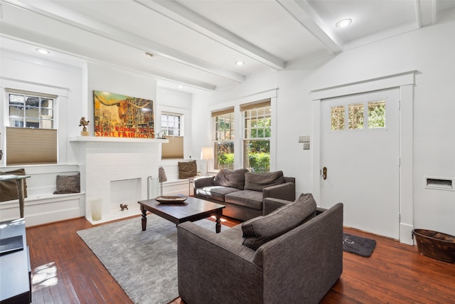 living room with beam ceiling, crown molding, dark wood-type flooring, and a brick fireplace