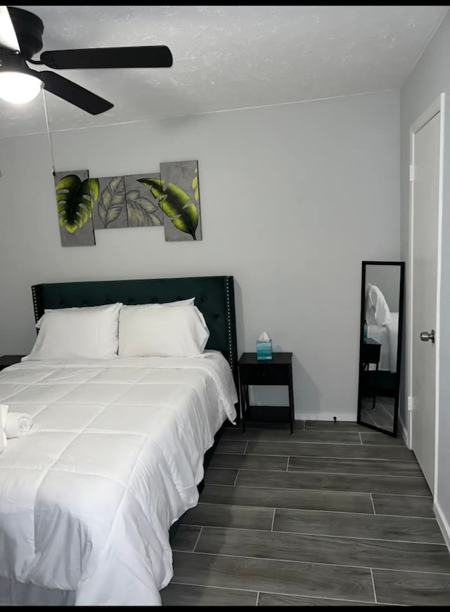 bedroom with ceiling fan and dark hardwood / wood-style flooring