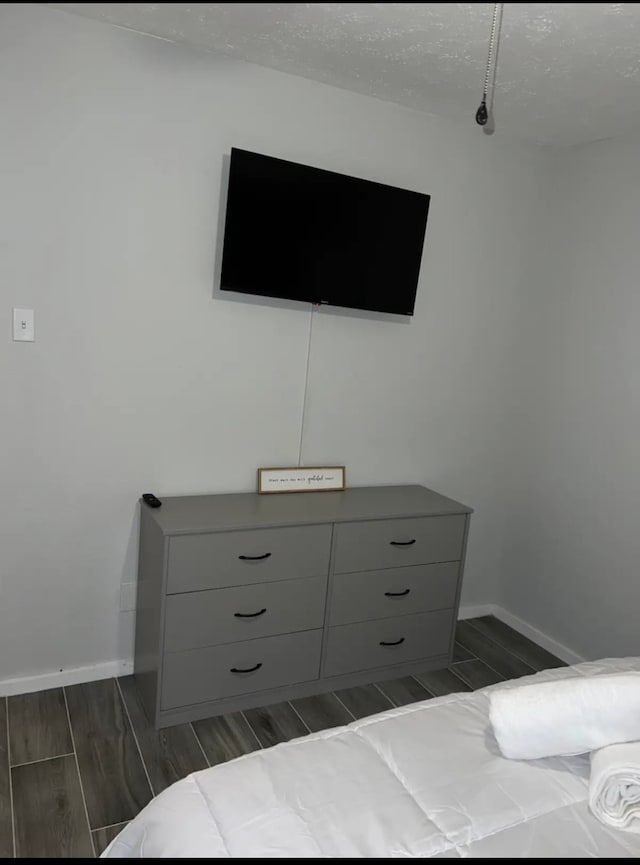 bedroom with dark wood-type flooring and a textured ceiling