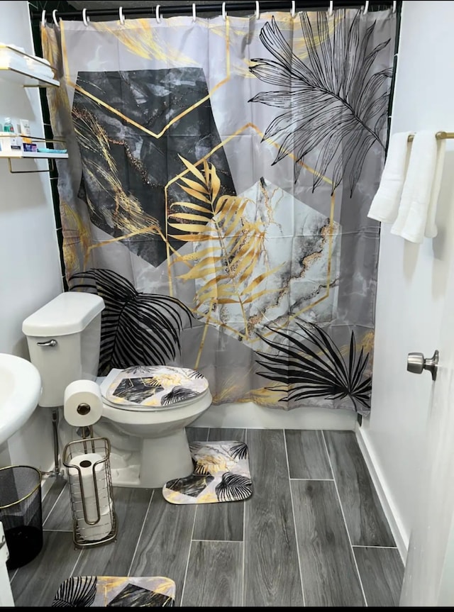 bathroom with toilet and hardwood / wood-style floors