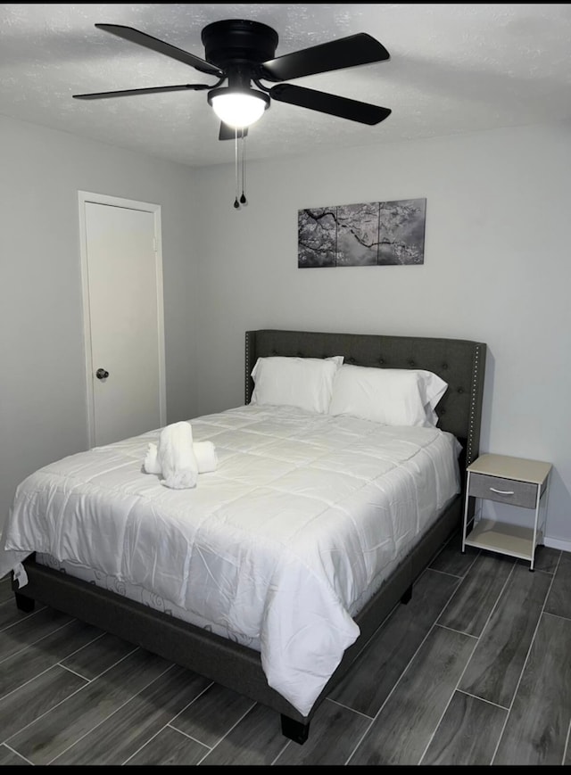 bedroom featuring ceiling fan and dark wood-type flooring