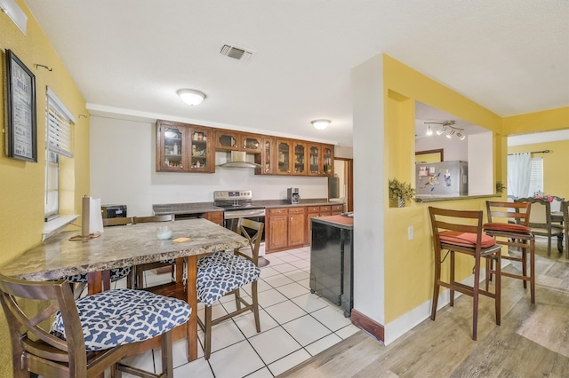 kitchen featuring rail lighting, stainless steel appliances, and light tile floors