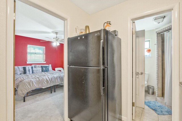 bathroom featuring ceiling fan, tile floors, and toilet