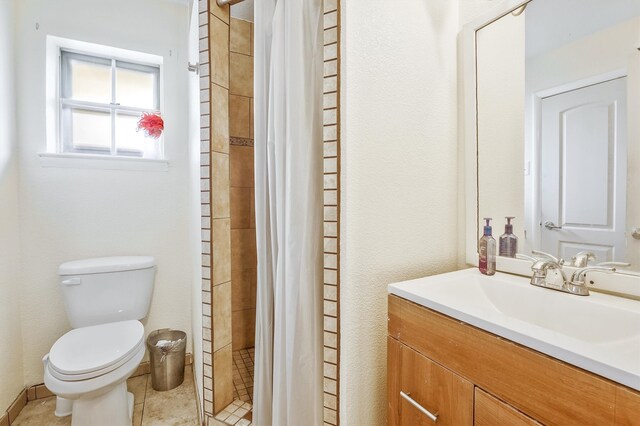 bathroom with toilet, tile floors, a tile shower, and large vanity