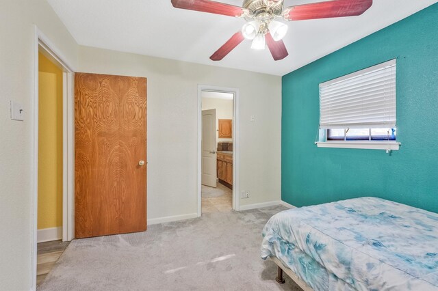 carpeted bedroom featuring ceiling fan and ensuite bathroom