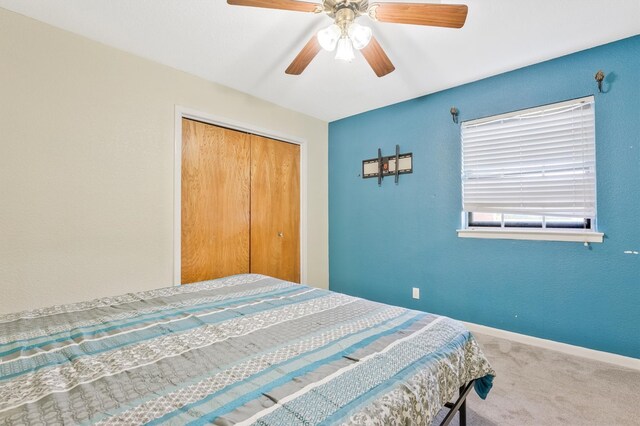 carpeted bedroom with a closet and ceiling fan