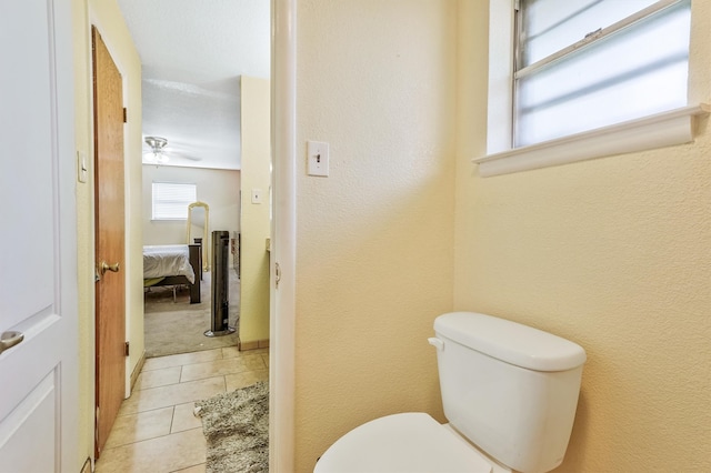 bathroom featuring ceiling fan, toilet, and tile flooring