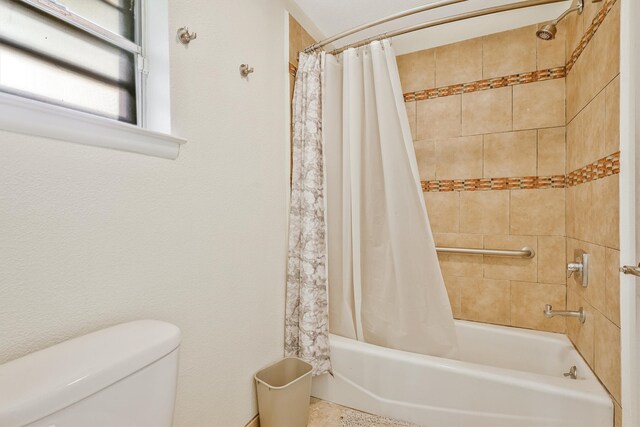 bathroom with shower / tub combo and toilet