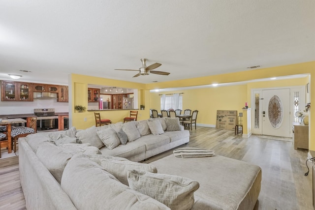 living room featuring light hardwood / wood-style flooring and ceiling fan