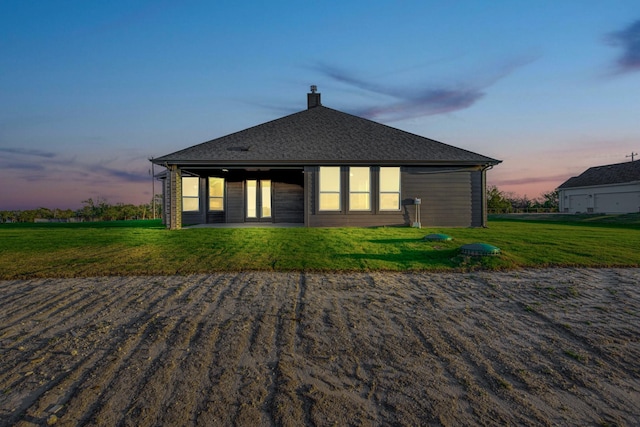 4201 Old Springtown Rd, Weatherford, TX 76085 - back of property at dusk with a chimney and a lawn