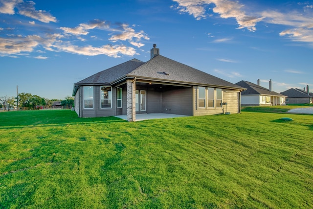 back of house with a patio area and a yard