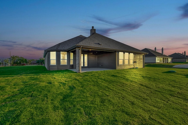 4201 Old Springtown Rd, Weatherford, TX 76085 - back of house at dusk with a patio area, a yard, and a chimney
