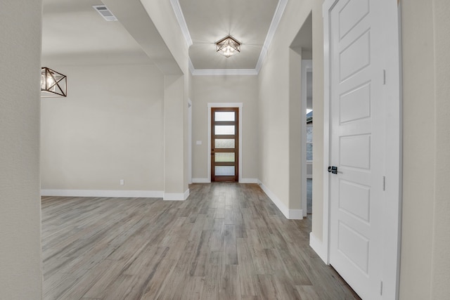 entrance foyer with light hardwood / wood-style flooring and crown molding