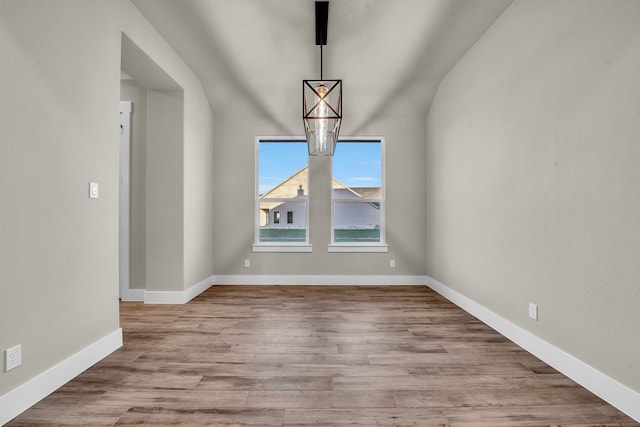 spare room featuring light hardwood / wood-style flooring and vaulted ceiling