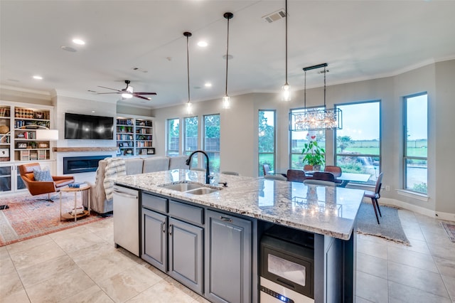 kitchen with dishwasher, a glass covered fireplace, a sink, and ornamental molding