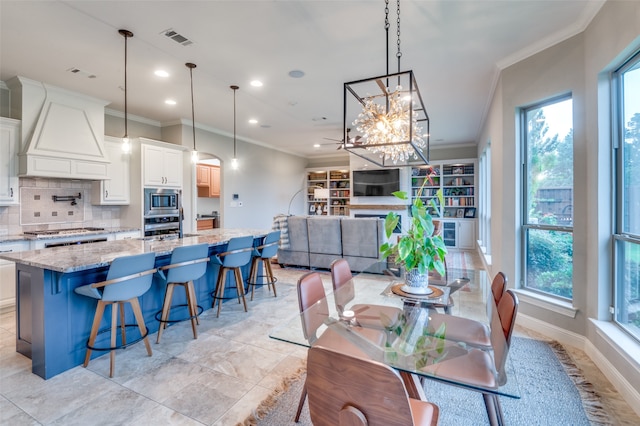 dining room featuring baseboards, visible vents, arched walkways, ornamental molding, and recessed lighting