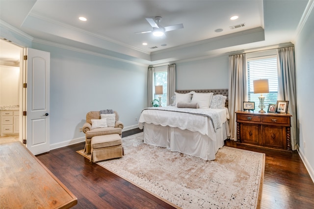 bedroom featuring dark wood-type flooring, a raised ceiling, visible vents, and ornamental molding