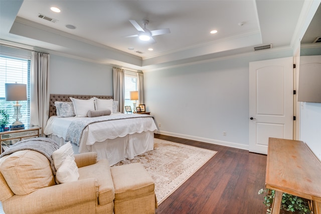 bedroom with a tray ceiling, multiple windows, and visible vents