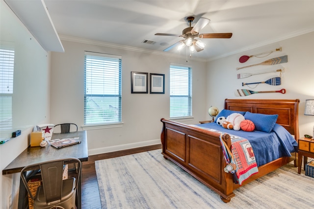 bedroom with visible vents, baseboards, a ceiling fan, wood finished floors, and crown molding