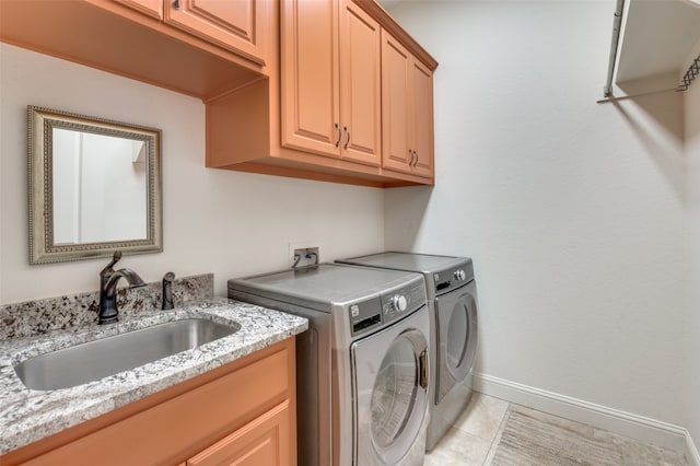 laundry room with light tile patterned floors, washing machine and dryer, a sink, baseboards, and cabinet space